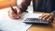 © Janthiwa - Calculating finances with pencil and calculator.