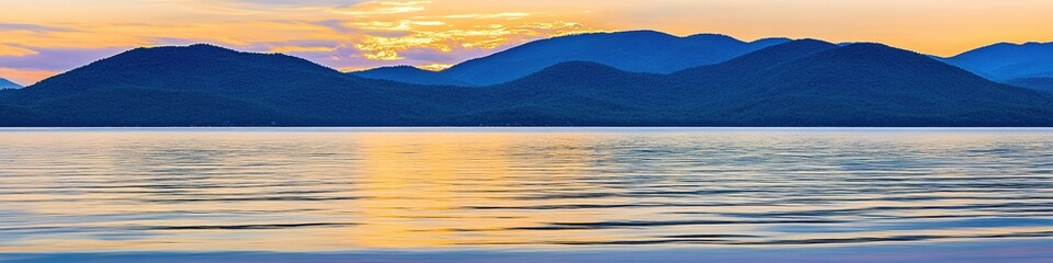 Poster - Serene lake view with dark mountains and golden sunset sky reflecting on the water surface