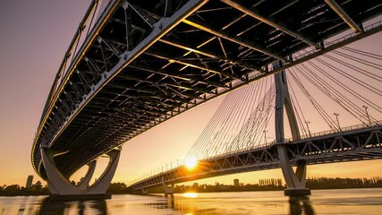 Fototapete - sunset over the river with a stunning view of the bridge and city skyline in the background