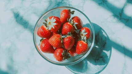 Wall Mural - Fresh Strawberries in Clear Bowl on Marbled Surface with Shadows