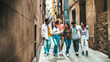 © Davide Angelini - Happy multiracial group of friends walking on city street - Cheerful young people hanging outside together - Friendship concept with guys and girls having fun outdoors