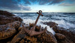 © SolaruS - Rusty anchor on rocky coast, dramatic ocean waves.  Perfect for concepts of strength, resilience, travel, or nautical themes. Ideal for websites, blogs, and print media.