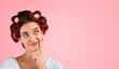 © Prostock-studio - Great Idea. Pensive Housewife With Hair Curlers Smiling Thinking About Something Holding Finger Near Mouth And Looking Aside Posing On Yellow Studio Background. Free Space For Text