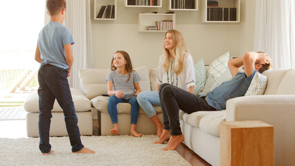 Wall Mural - Family Sitting On Sofa At Home Playing Game Of Charades