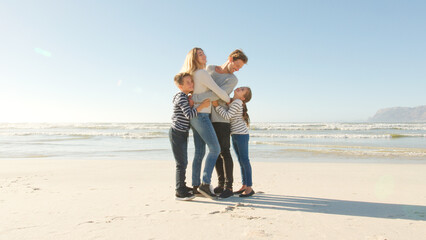 Wall Mural - Portrait Of Loving Family On Winter Beach Vacation Hugging One Another On Shoreline