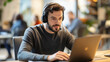 © Natalia Klenova - Focused man with headset working on laptop in cafe