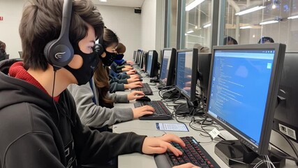 Fototapete - This Young learners focus on coding tasks while wearing masks and using computers in a lab.