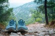 © Hunman - A pair of running shoes placed on a rocky path with a scenic forest view.