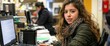 © Nas - Young woman working on laptop in office.