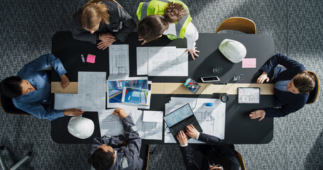 Aufkleber - Top Down View of Diverse Team of Real Estate Construction Engineers Working With Blueprints and Documents in an Office. Workspace Of Housing Development Company with Colleagues Using Laptop and Tablet