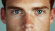© KN Studio - Intense Gaze: Close-up portrait of a young man with striking blue eyes and freckles, his direct gaze conveying a sense of intensity and confidence.