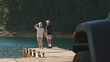 © Monkey Business - Rear View Of Senior Couple On Road Trip In Convertible Car Standing On Wooden Jetty By Lake