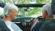 © Monkey Business - Rear View Of Senior Couple On Road Trip In Convertible Car Driving Along Tree Lined Road