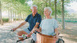© Monkey Business - Senior Retired Couple On Vacation Cycling Along Tree Lined Country Road In Summer