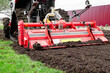 © Natalia - Plowing and milling the land on a garden plot. A crawler tractor with a milling cutter plows the land