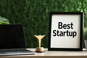 Wall Mural - award for best startup displayed on a desk with greenery backdrop.