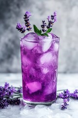 Wall Mural - A glass of purple drink with ice and lavender flowers on top. The drink is purple and has ice in it