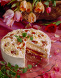 © Mamo - Deliciously decorated creamy Plum cake with flowers and sliced portion on a table with vibrant colors