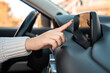 © Daniel - A female driver using a phone navigator in the car,
