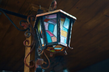 a multi-colored lantern made of metal and glass mosaic