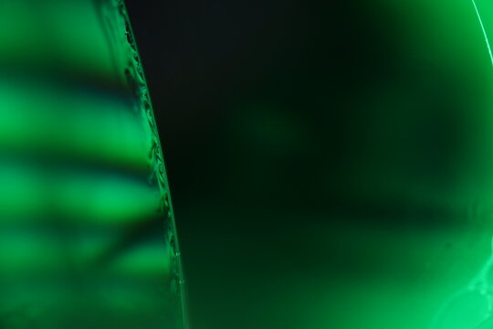 	
Green liquid surface on the dark background, colourful abstract, green shapes, minimalism, line of light, black and green