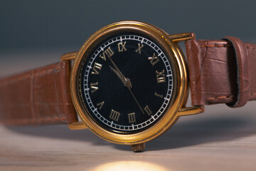 luxury wrist watch with leather strap on dark background