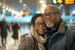 © Markus Schröder - Portrait of a tender multicultural couple in their 50s wearing a cozy sweater over busy airport terminal