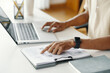 © DragonImages - Close-up of manager working on his workplace, he reading document and typing on laptop