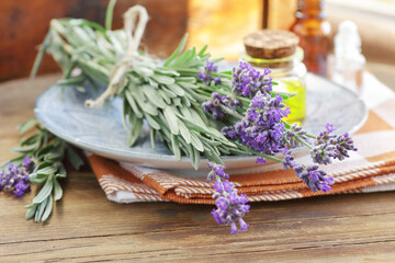 Wall Mural - Lavender bouquet with oils or extracts  on wooden background with fresh flowers, copy space, natural medicine,  natural hair and skin treatment, aromatherapy concept