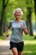 © Vadym - Happy senior woman jogging in park. Active retired female enjoys fitness outdoors. Smiles, runs in nature. Healthy lifestyle. Active senior citizen. Mature woman exercising. Positive, joyful person.