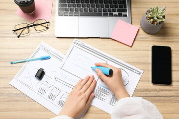 Leinwandbilder - Website designer creating wireframe on paper with highlighter at wooden table, above view