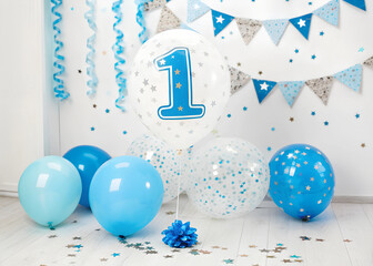 Wall Mural - festive celebration of the first birthday with balloons and confetti in blue tones, an inflatable ba