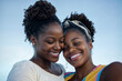 © Cadengo - The image shows two individuals with their heads close together, smiling and displaying natural hair styled in bun formations