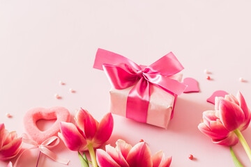 Wall Mural - Pink tulips and hearts, gift box with ribbon on light pink background