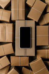 Poster - Top view of a blank screen smartphone resting on a cardboard parcel box among other packages