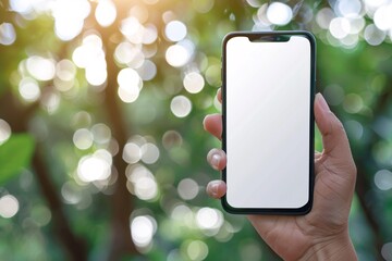 Fototapete - Hand holding smartphone with white screen on blurred green background