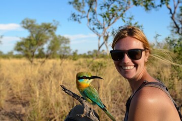 a rainbow bee-eater perched on a branch, its iridescent feathers catching the sunlight in kakadu nat