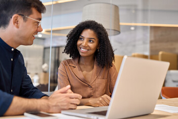 Aufkleber - Two happy young busy diverse sales professional business people company work team colleagues working together on laptop computer or manager consulting client at office corporate meeting.