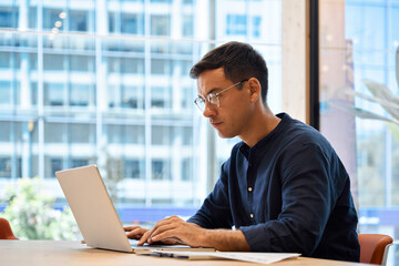 Aufkleber - Busy young professional business man executive, male corporate employee, Hispanic businessman investor or manager wearing glasses typing on computer technology using laptop working at office desk.