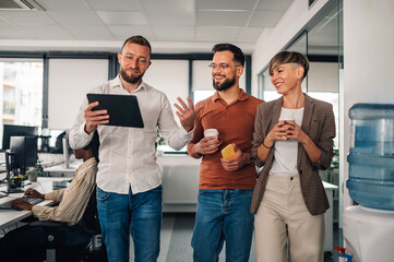 Businesspeople walking and talking in modern office using digital tablet