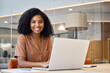 © insta_photos - Portrait of happy young African American business woman employee using laptop computer at work in office. Professional smiling businesswoman executive, company worker manager looking at camera.