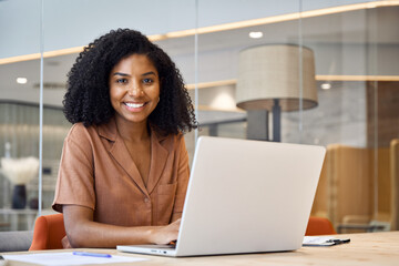 Aufkleber - Portrait of happy young African American business woman employee using laptop computer at work in office. Professional smiling businesswoman executive, company worker manager looking at camera.