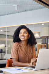 Aufkleber - Happy young African American business woman employee using laptop at work in office. Professional busy businesswoman executive, company worker or manager looking away working at computer. Vertical