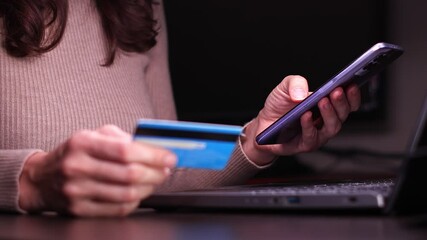 Female hands of cardholder holding credit card making e bank online payment. View of woman consumer paying for purchase in web store using smartphone technology. Ecommerce website payments concept.