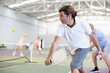 © JackF - Two athletic men of different ages are playing a game of pickleball on a court inside a sports facility