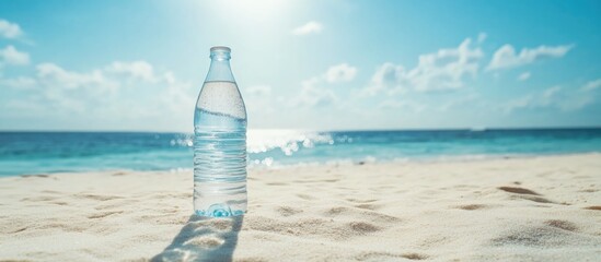 Poster - Bottle of water on sandy beach with ocean and blue sky in background Copy Space