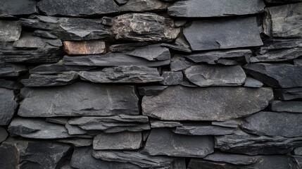 Wall Mural - Textured dark slate stone wall with varying sizes of stone for architectural backgrounds and design elements Copy Space