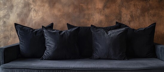 Poster - Modern couch with black cushions against textured brown wall showcasing interior design elements and Copy Space for text placement.