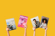 © Pixel-Shot - Female hands with different magazines on yellow background