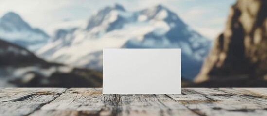 Poster - Blank business card on rustic wooden table with mountain landscape background and Copy Space for text insertion